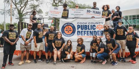Staff members of the Cook County Public Defender’s Office standing in front of a parade float.